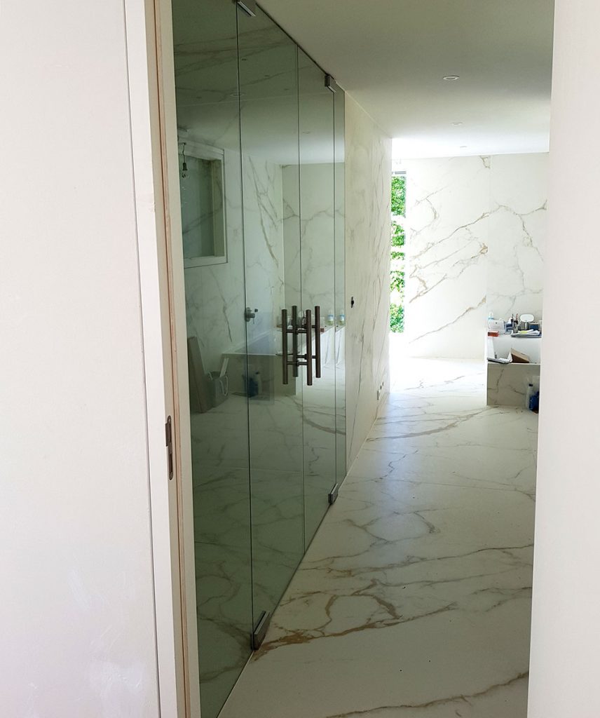 Duschabtrennung mit Türen in einem Marmor Bad